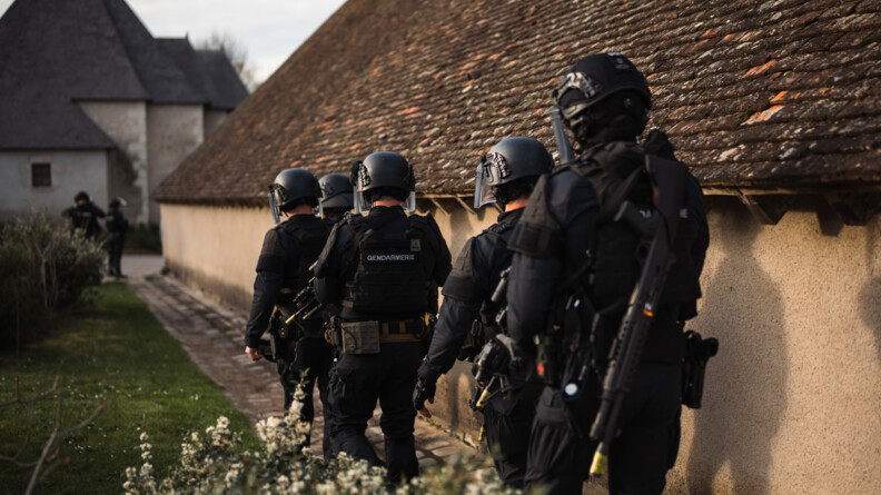 Des gendarmes d'un PSIG en colonne le long d'une habitation à proximité de Chambord