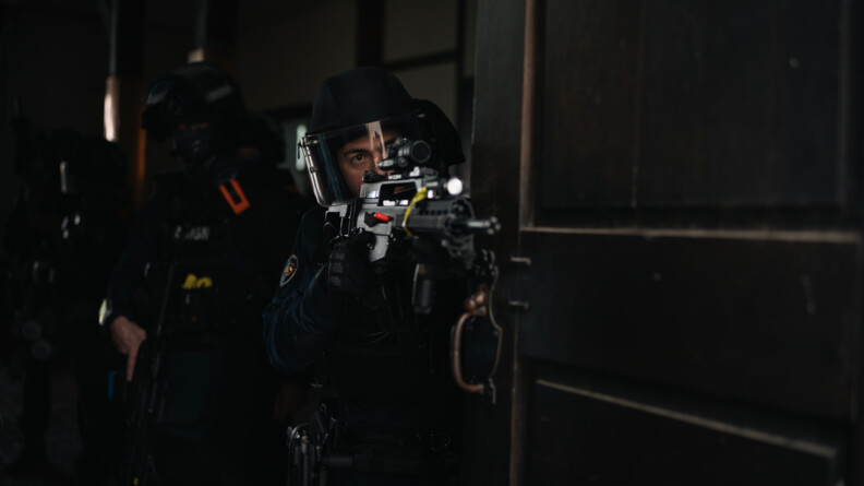 Un gendarme du PSPG avec un opérateur de l'AGIGN derrière lui dans le sombre