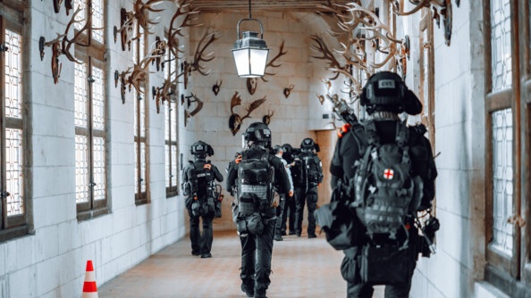 Plusieurs opérateurs AGIGN marchent dans la salle des trophées de chasse du château de chambord