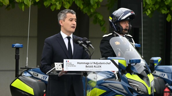 Discours du ministre Gérald Darmanin devant un motocycliste de la gendarmerie avec sa moto.