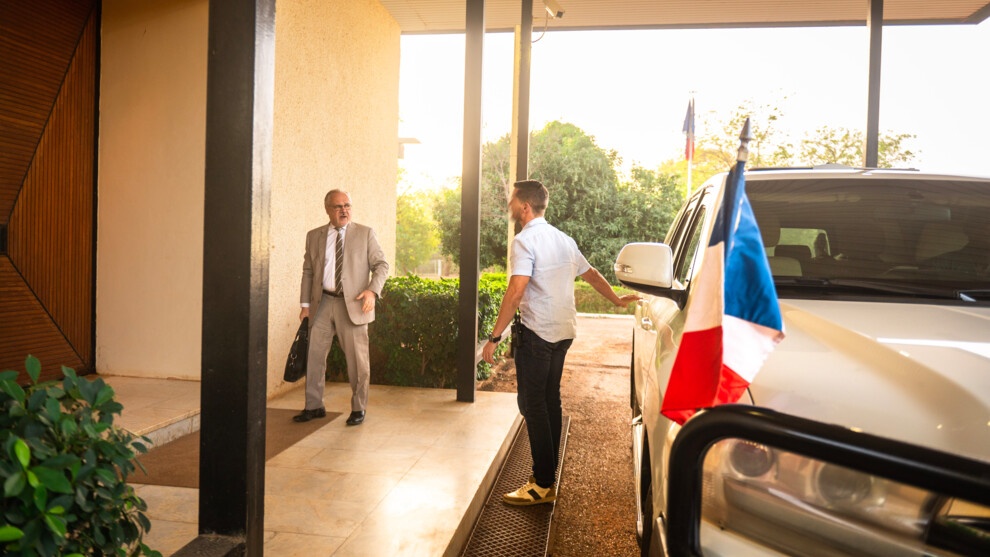 Un gendarme assurant la protection des hautes personnalités ouvre la portière à l'ambassadeur de France au Niger.