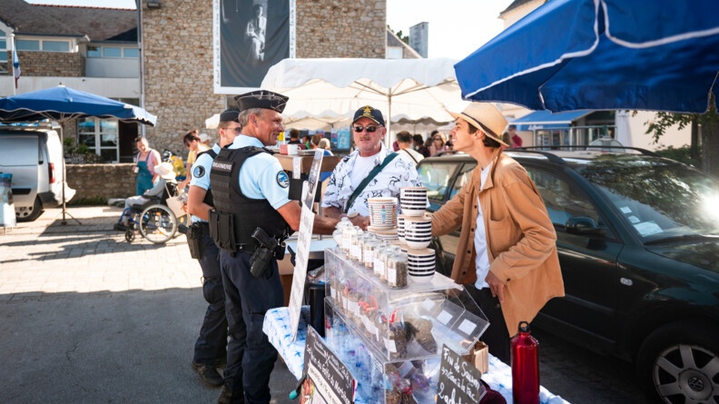 Patrouille à pied de deux gendarmes du poste provisoire sur le marché de l'Île aux Moines.