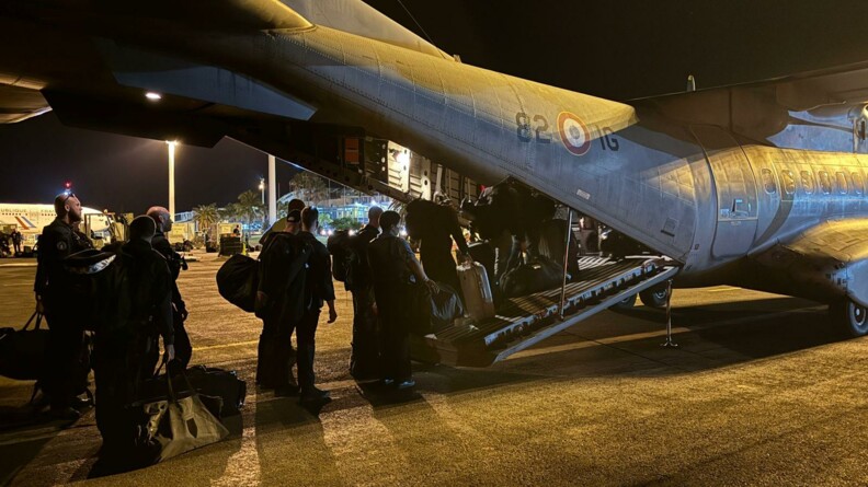 Départ en avion de nuit de gendarmes mobiles à l'aéroport de Nouméa.
