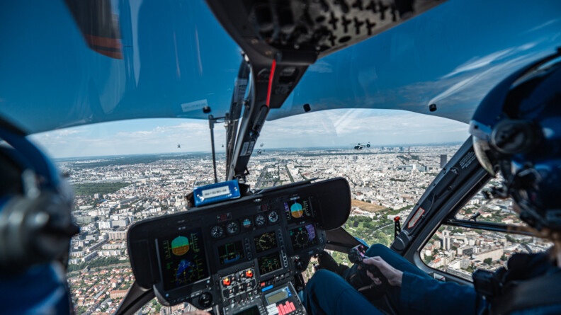 Vue de Paris à partir d'un cockpit d'hélicoptère de la gendarmerie, avec deux personnels naviquant à bord