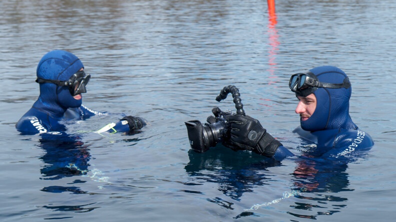 Plan resseré sur les deux gendarmes dans l'eau entrain d'effectuer des photos et autres relevés.