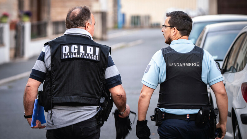 Un gendarme de l'OCLAESP de dos avec à sa droite un gendarme d'une unité de recherches.