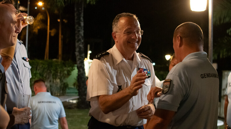 Le directeur général de la gendarmerie nationale, souriant, discutant avec un gendarme que l'on voit de dos