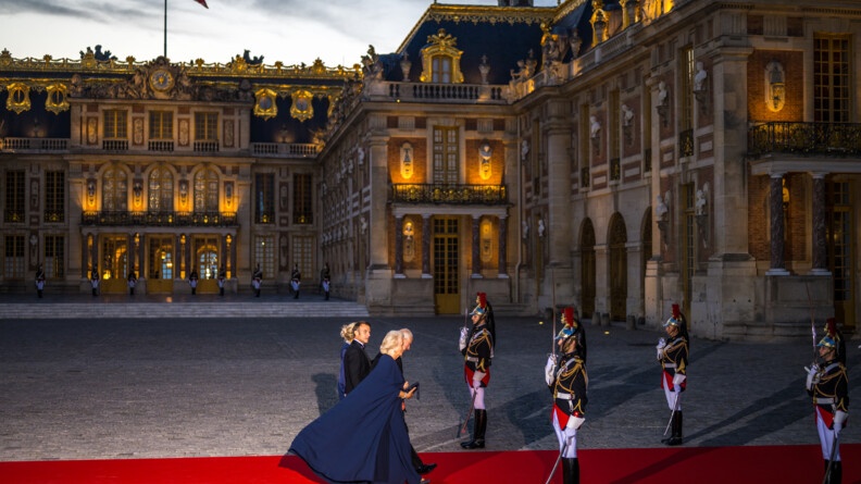 Le couple royal et le couple présidentiel, entre ensemble dans le château de Versailles, entourés de militaires de la Garde Républicaine.