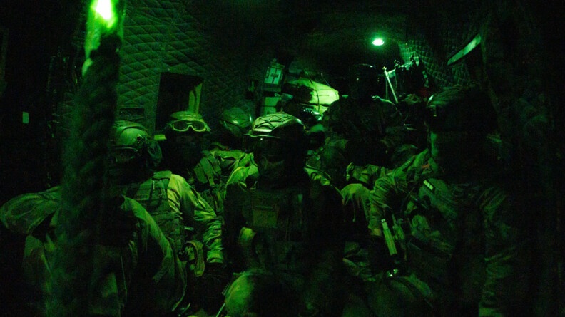 Militaires dans la cabine de l'hélicoptère de nuit.