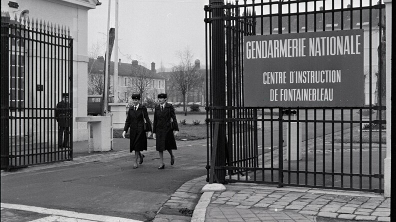 Deux femmes gendarmes sortent par le portail du centre d'instruction de Fontainebleau
