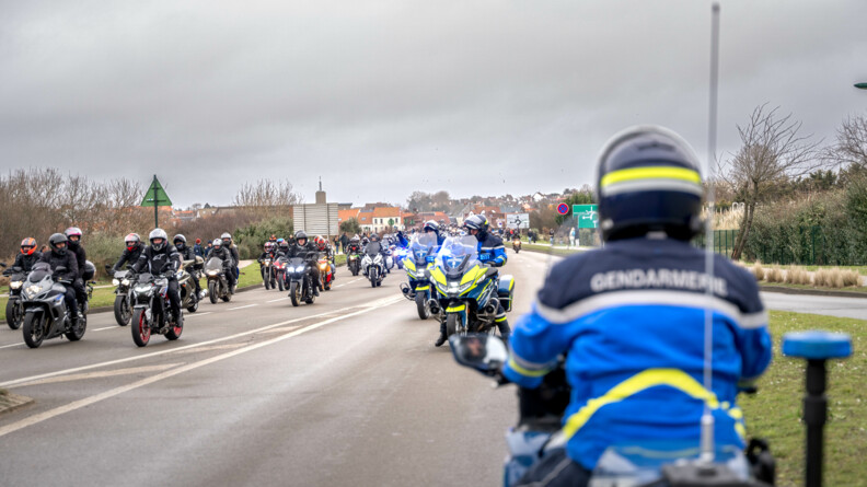 Photo de trois gendarmes EDSR sur leurs motos, assurant la sécurité routière face au cortège de motos. Sur la gauche et dans le fond on aperçoit une foule de motards arriver.