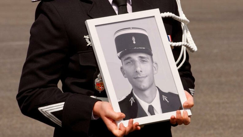 Le portrait en noir et blanc du major Jeansanetas, présenté par une gendarme dont on ne voit que le buste.