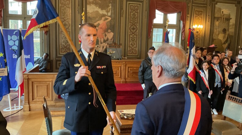 Le chef d’escadron, commandant l’EGM 16/1, (de face) remet au maire de Courbevoie (de dos) une copie du fanion de l’unité.