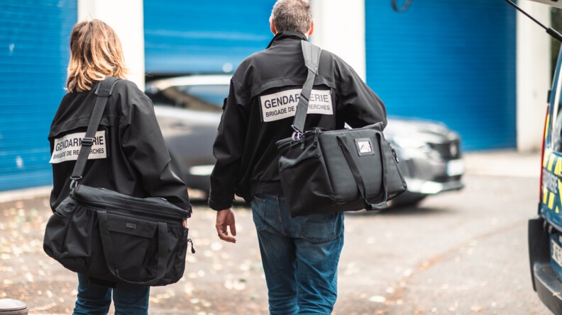 Deux gendarmes en civil vêtus du blouson noir floqué "brigade de recherches" porteur de sacs noirs en bandoulière