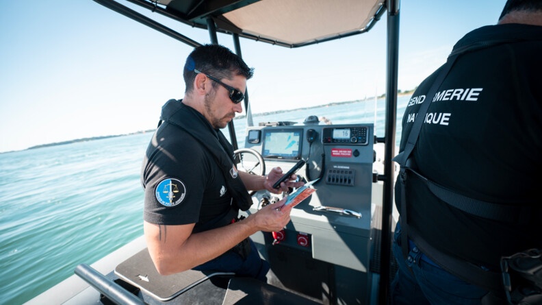 Un gendarme de la brigade nautique de Quiberon contrôle les papiers d'un bateau lors d'un contrôle en mer.