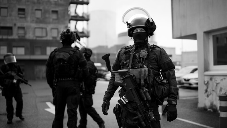 Photo en noir et blanc d'un militaire du PSPG armé regardant l'objectif.