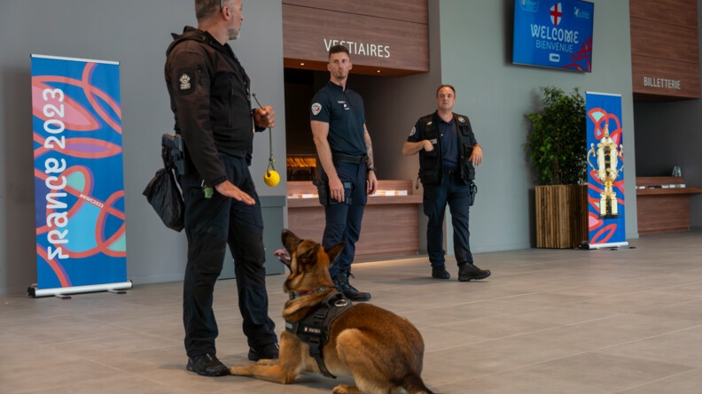 Un gendarme et son chien ansi que deux hommes de la police debout dans le hall d'accueil du Palais des congrès du Touquet