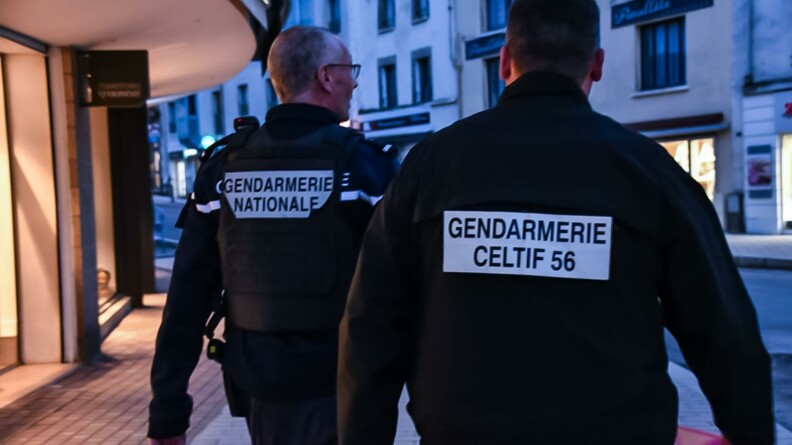 Deux gendarmes de dos, dont un d'une Cellule de lutte contre le travail illégal et les fraudes, en patrouille dans les rues.