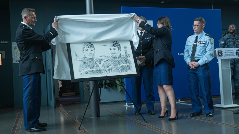 Deux gendarmes soulève un drap blanc pour faire découvrir un tableau sur l'exposition de la GTA