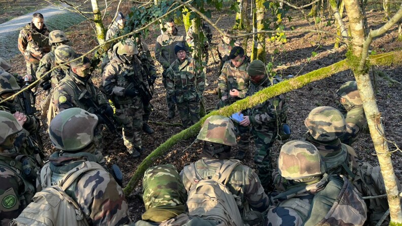 20 gendarmes regroupés au milieu de la forêt en tenue de combat.