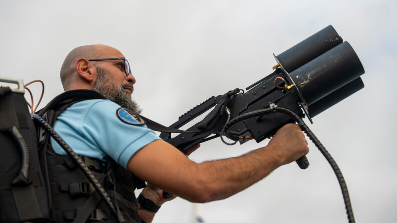 Gendarme tenant 'un fusil anti-drone orienté vers le ciel