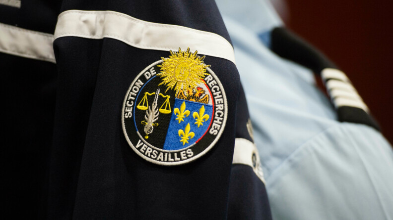 Sur une veste de gendarmerie bleue marine,apparait un écusson portant l'inscription Section de recherches Versailles