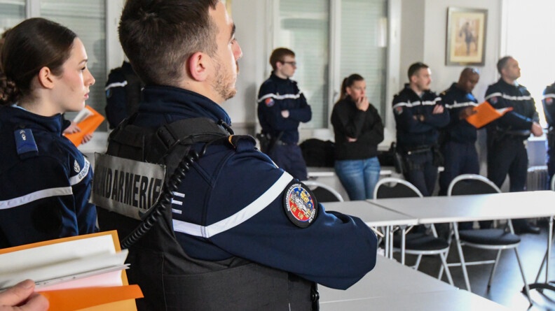 Huit gendarmes autour d'un tabl grise en briefing