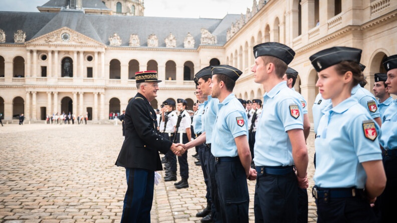Le général d'armée Christian Rodriguez serre la main d'un des réservistes de la gendarmerie dans la courd'honneur des Invalides.