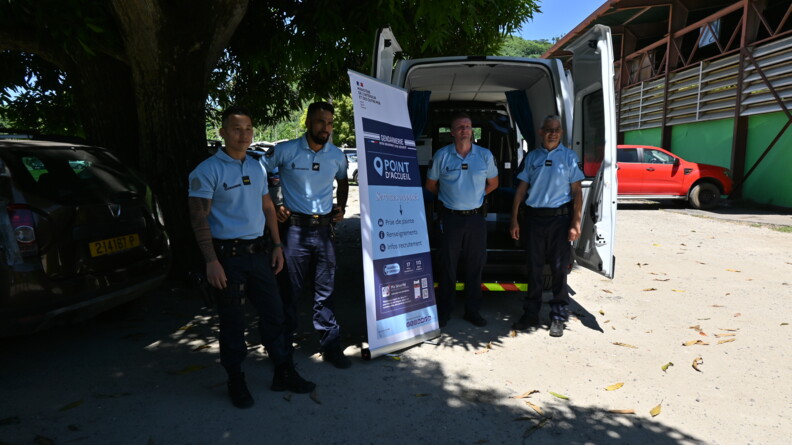 En extérieur et de jour, quatre gendarmes posent devant la nouvelle brigade territoriale mobile : le Gendtruck