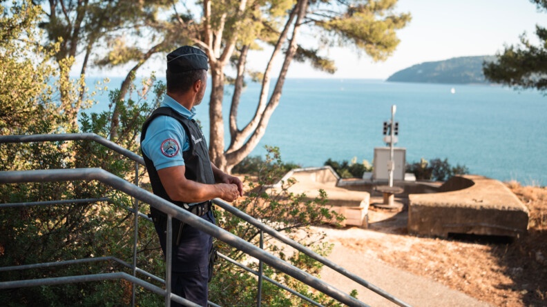 Sous un grand ciel bleu en extérieur, un militaire de la GARM regarde un radar qui donne sur la passe de Toulon