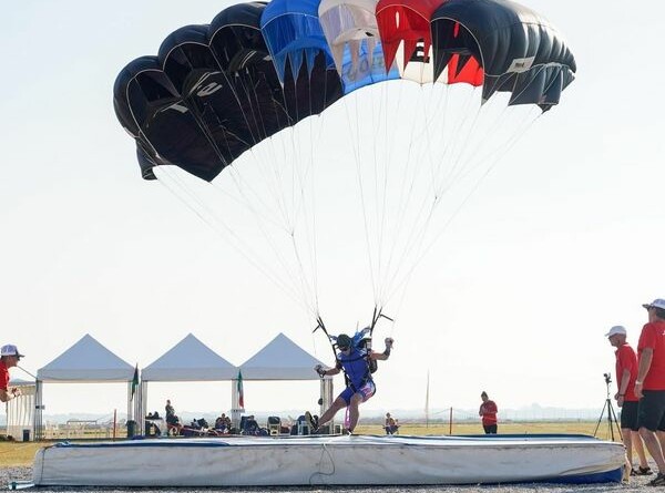 Une parachutiste atterit sur un socle posé au sol lors d'une épreuve de précision d’atterrissage