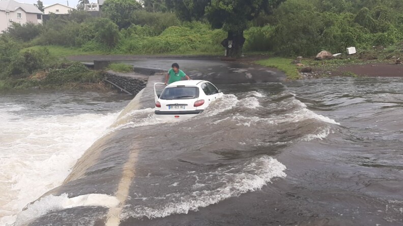 Un véhicule et son conducteur pris dans un cours d'eau en crue sur l'île de La Réunion.