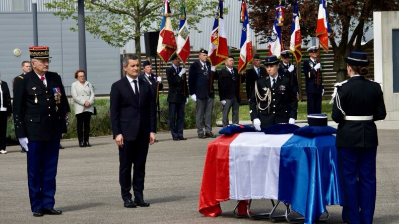 Le directeur général de la gendarmerie nationale et le ministre de l'Intérieur et des Outre-mer au garde-à-vous devant le cercueil du major Jeansanetas, recouvert du drapeau tricolore.
