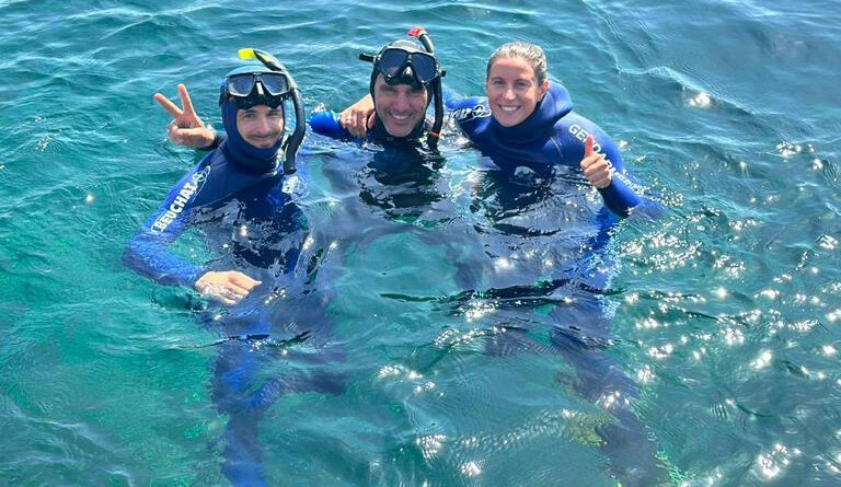 Charlotte Bonnet et deux plongeurs de la gendarmerie à sa droite, dans l'eau de la Méditerranée.