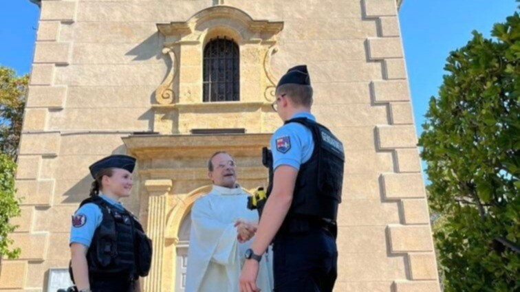 Devant une église, deux gendarmes des Bouches-du-Rhône, échangent avec un prêtre.