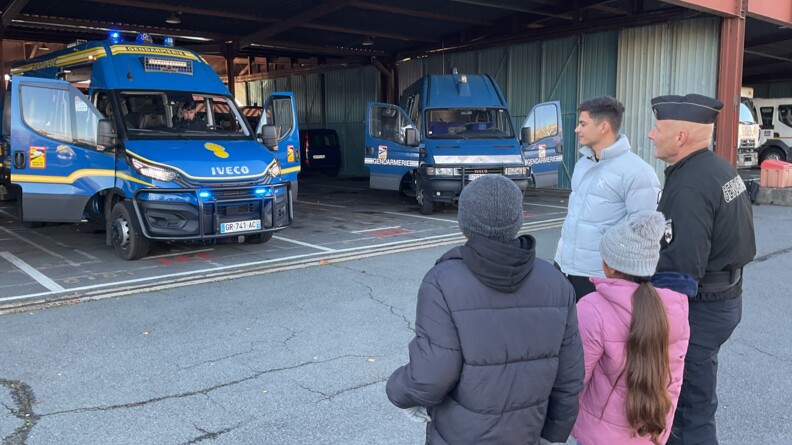 Les deux enfants se tenant devant les nouveaux véhicules de la gendarmerie mobile.