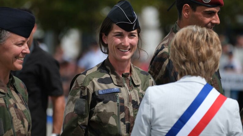 La maréchale des logis-cheffe Léocadie Ollivier de Pury, sportive de haut niveau de la Défense - gendarmerie, échange avec une élue avec son écharpe bleu blanc rouge.