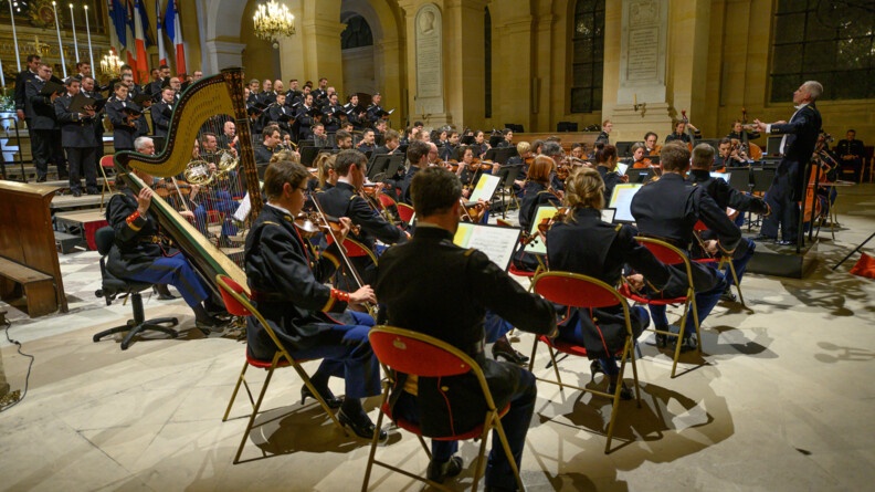 Vue de dos des musiciens de l'orchestre de la Garde républicaine et vue de face du choeur de l'armée française, dans la cathédrale Saint-Louis aux Invalides à Paris