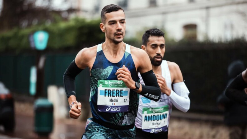 Mehdi Frère courant le marathon de Paris et un second coureur en arrière plan à sa gauche