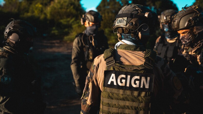 Un militaire de l'AGIGN de Mayotte vu de dos, entouré de quatre autres gendarmes de l'unité.