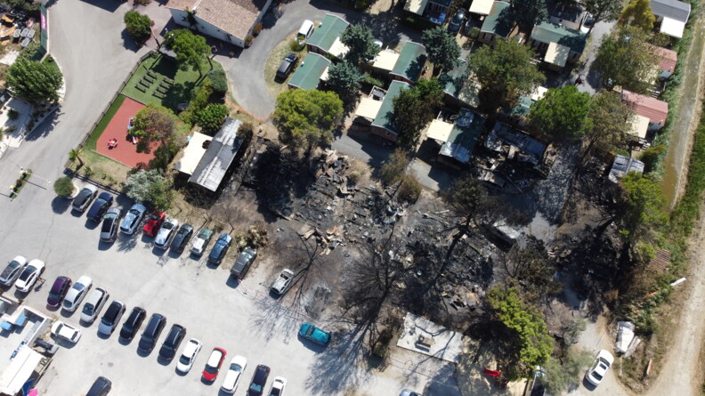 Vue aérienne montrant l'état du camping après l'incendie. En bas se situe le parking, au milieu de la photo la partie ravagée par l'incendie et en haut les mobil-homes qui n'ont pas été atteints.