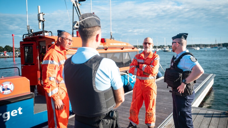 Deux gendarmes échangent avec des sauveteurs de la SNSM à Port-Blanc, dans le Morbihan.