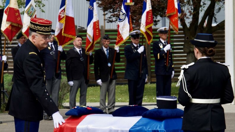 Le directeur général de la gendarmerie nationale se recueille devant le cercueil de Loïc Jeansanetas, la main droite posée sur le cercueil recouvert du drapeau tricolore.