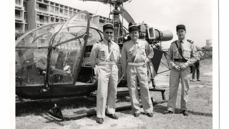 Trois gendarmes devant un hélicopère Alouette II de la gendarmerie.
