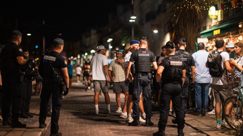 Photo nocturne montrant six militaires d'un peloton d'intervention de gendarmerie mobile appelés pour calmer certains esprits échauffés par l'alcool sur la terrasse d'un bar.