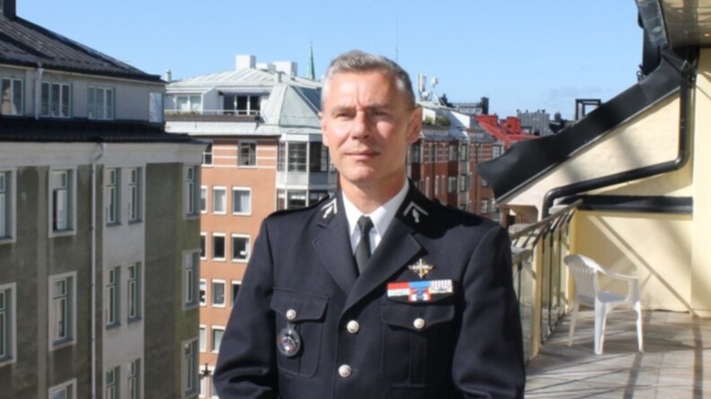 Le colonel Erwan Hénault en vareuse devant des immeubles sur un balcon.