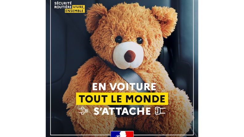 Un ours en peluche attaché dans une voiture avec sa ceinture de sécurité.