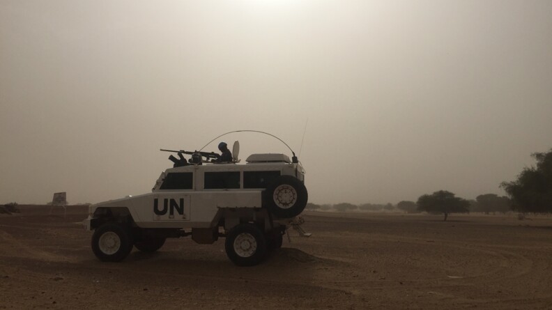Véhicule des Nations Unies patrouillant dans le désert avec un tireur.