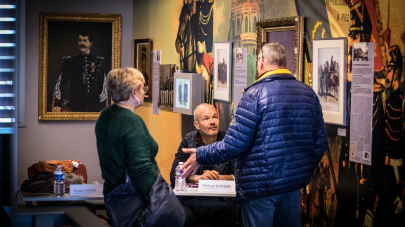 Discussion entre un auteur et des visiteurs au salon littéraire de l'EOGN, le 1er avril, au musée de la gendarmerie nationale.