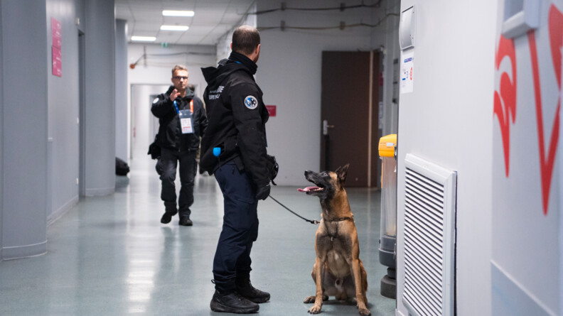 Une équipe cynophile inspecte les couloirs à l'intérieur du Stade de France. A gauche, le gendarme, à droite le chien qui le regarde.